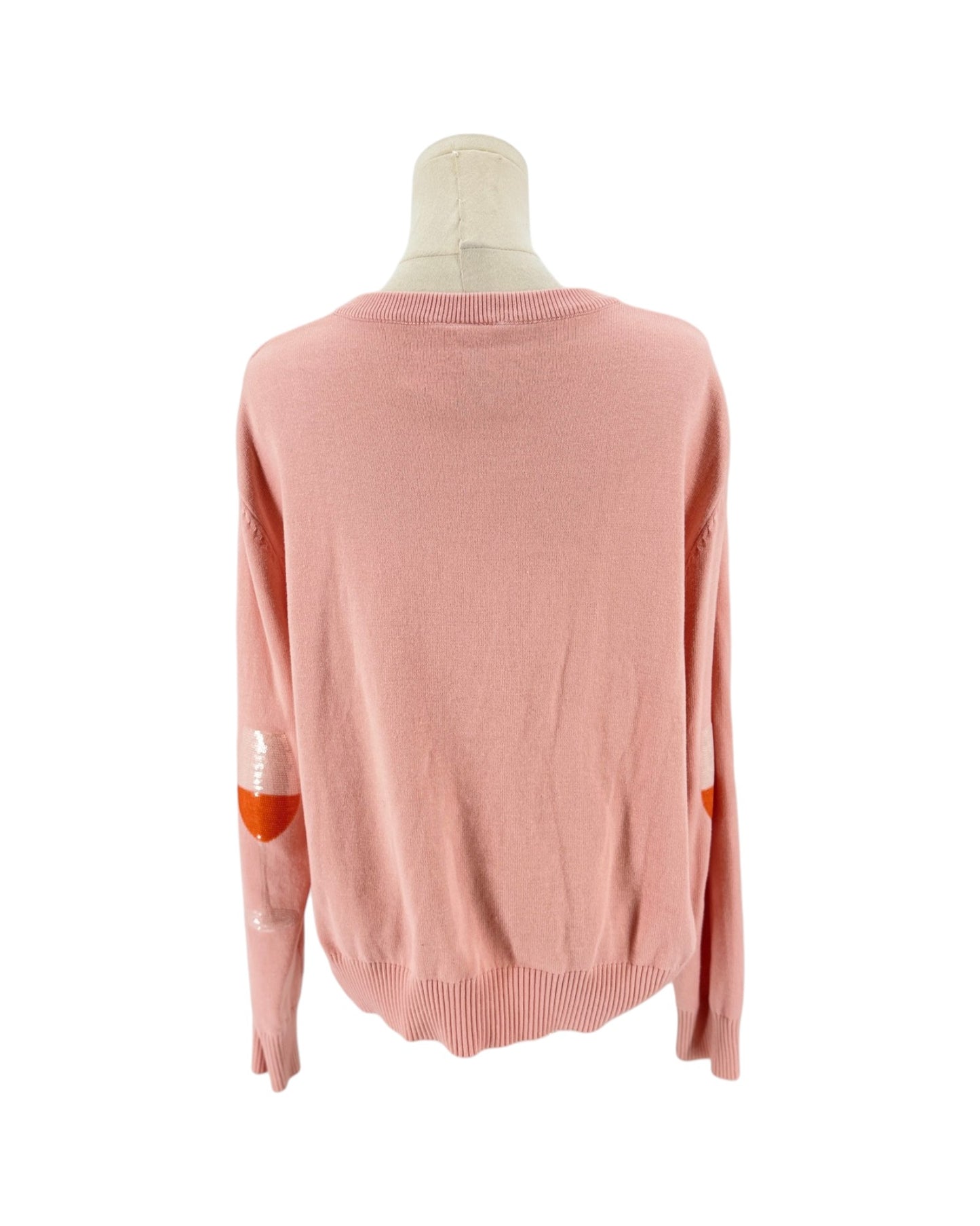 A light pink knit sweater displayed on a mannequin from the back, featuring orange elbow patches and white embroidered details on the sleeves.