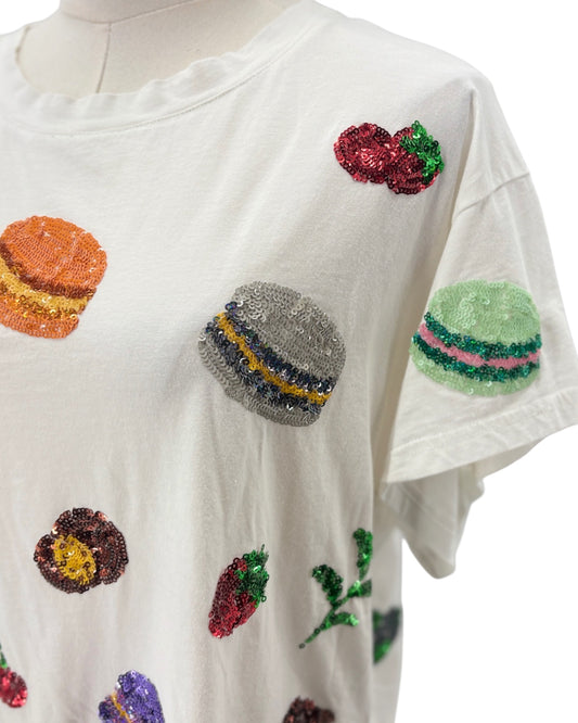 White t-shirt with colorful sequin embellishments on a mannequin.