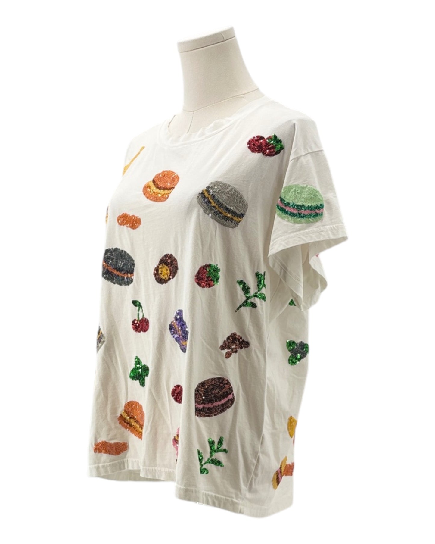 Mannequin wearing a white shirt with colorful embroidered designs on a white background