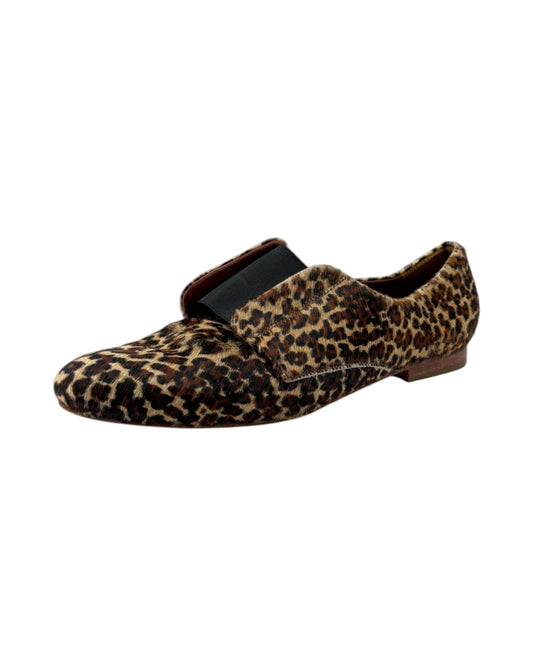 Leopard print slip-on shoe with a black strap on a white background