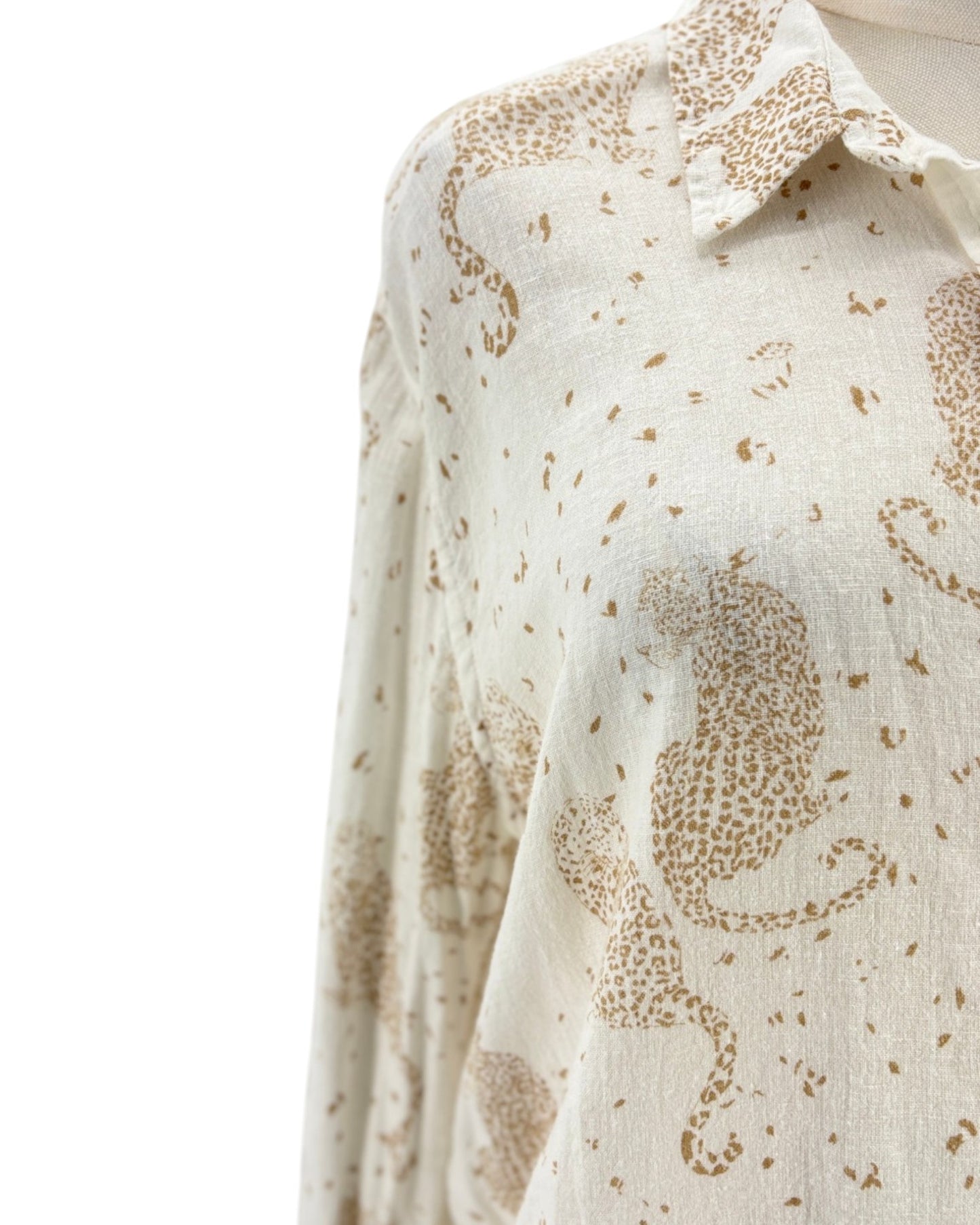 Cream colored long sleeve button down shirt with tan leopards on a mannequin on a white background