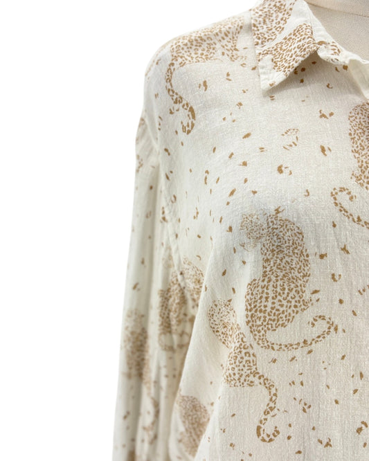 Cream colored long sleeve button down shirt with tan leopards on a mannequin on a white background