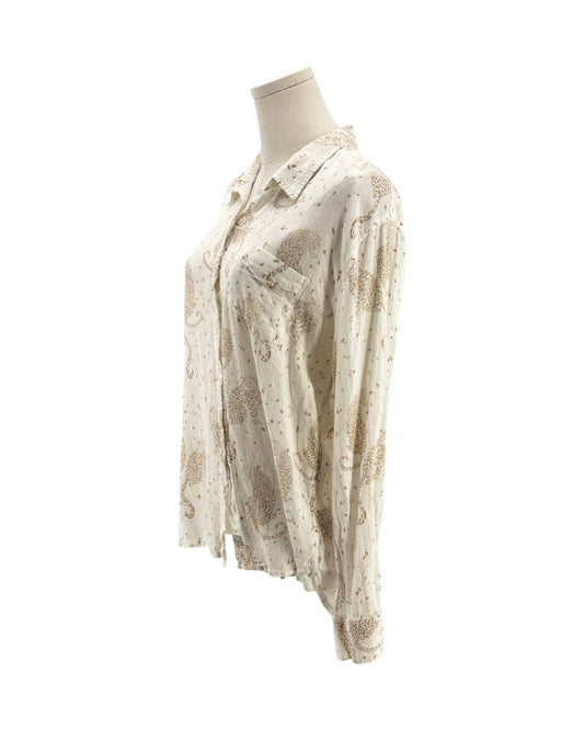Cream colored long sleeve button down shirt with tan leopards on a mannequin on a white background