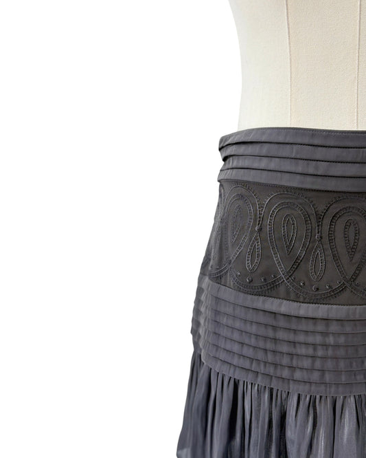 Gray skirt with intricate design and fringes on a white background