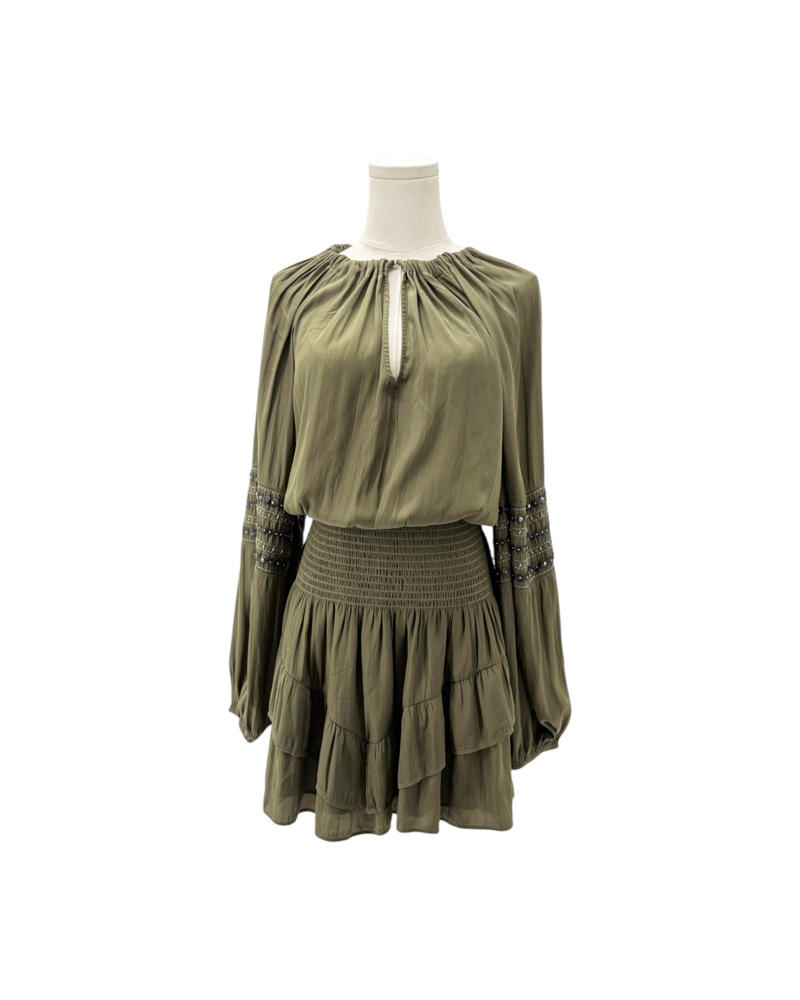 An olive green long-sleeve mini dress with a smocked waist and embroidered cuffs, displayed on a mannequin torso against a white background.