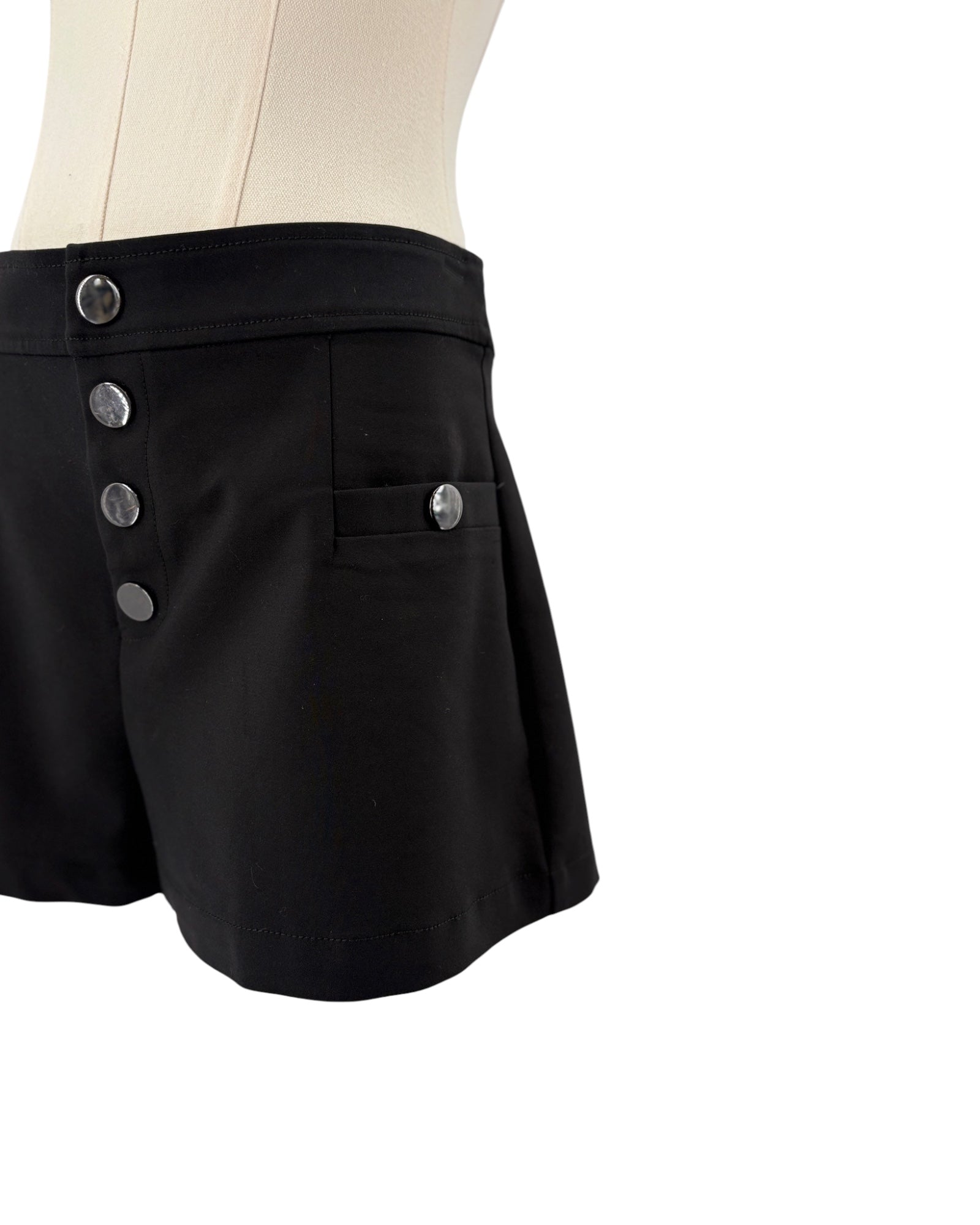 Black shorts with silver buttons on a mannequin against a white background