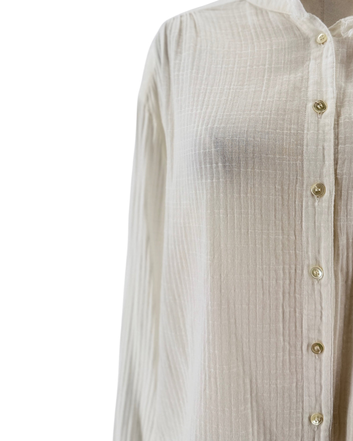 White button down blouse with a raw edge neckline and cuffs, round neckline, long sleeve with button cuff, front button-down closure, transparent fabric on a white background on a mannequin