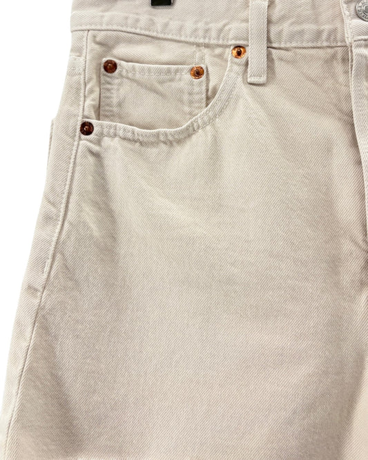 Close-up of beige denim shorts with button details on a white background