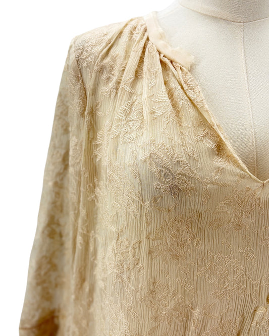 cream blouse with embroidery on a mannequin against a white background