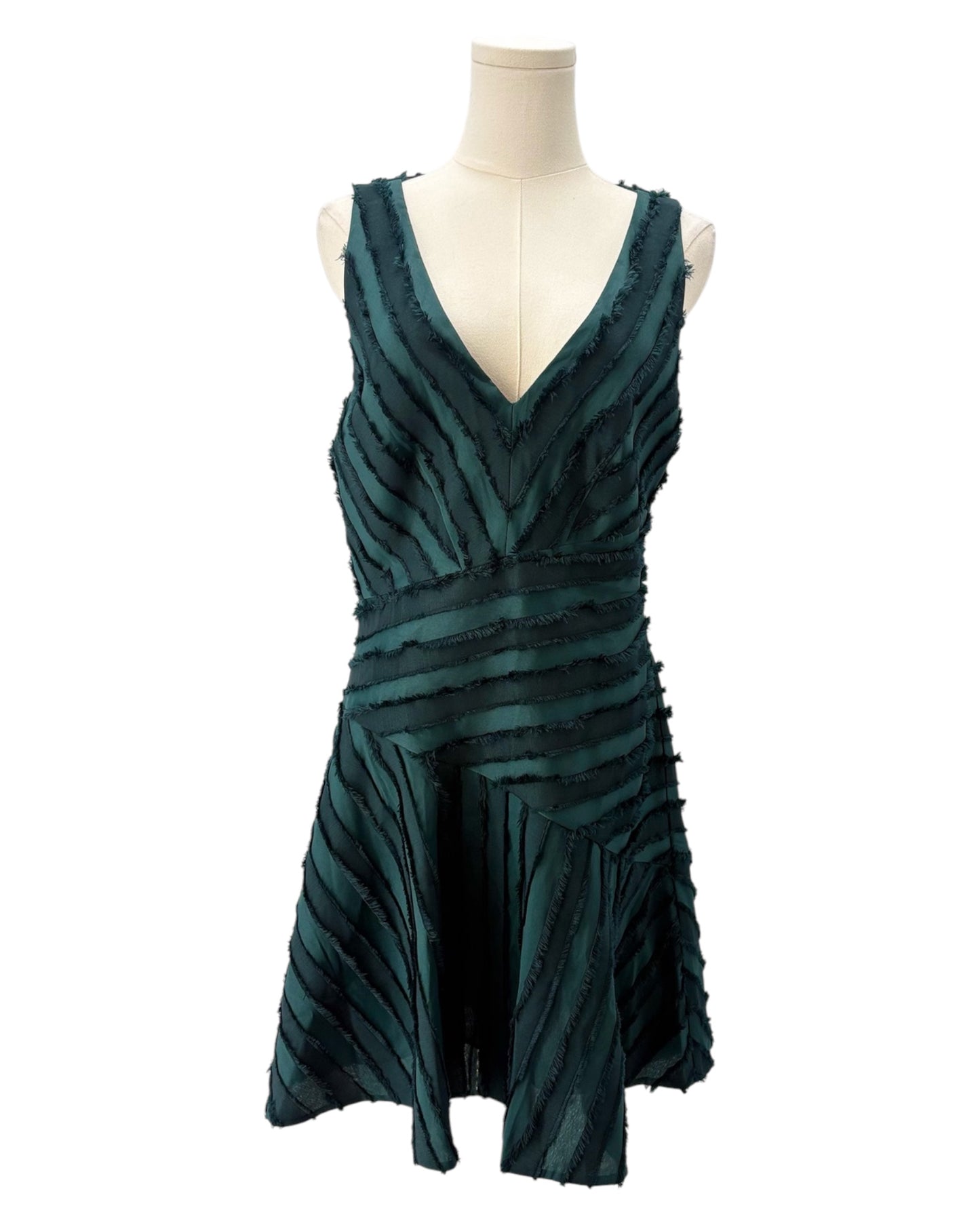 Teal dress on a mannequin against a white background