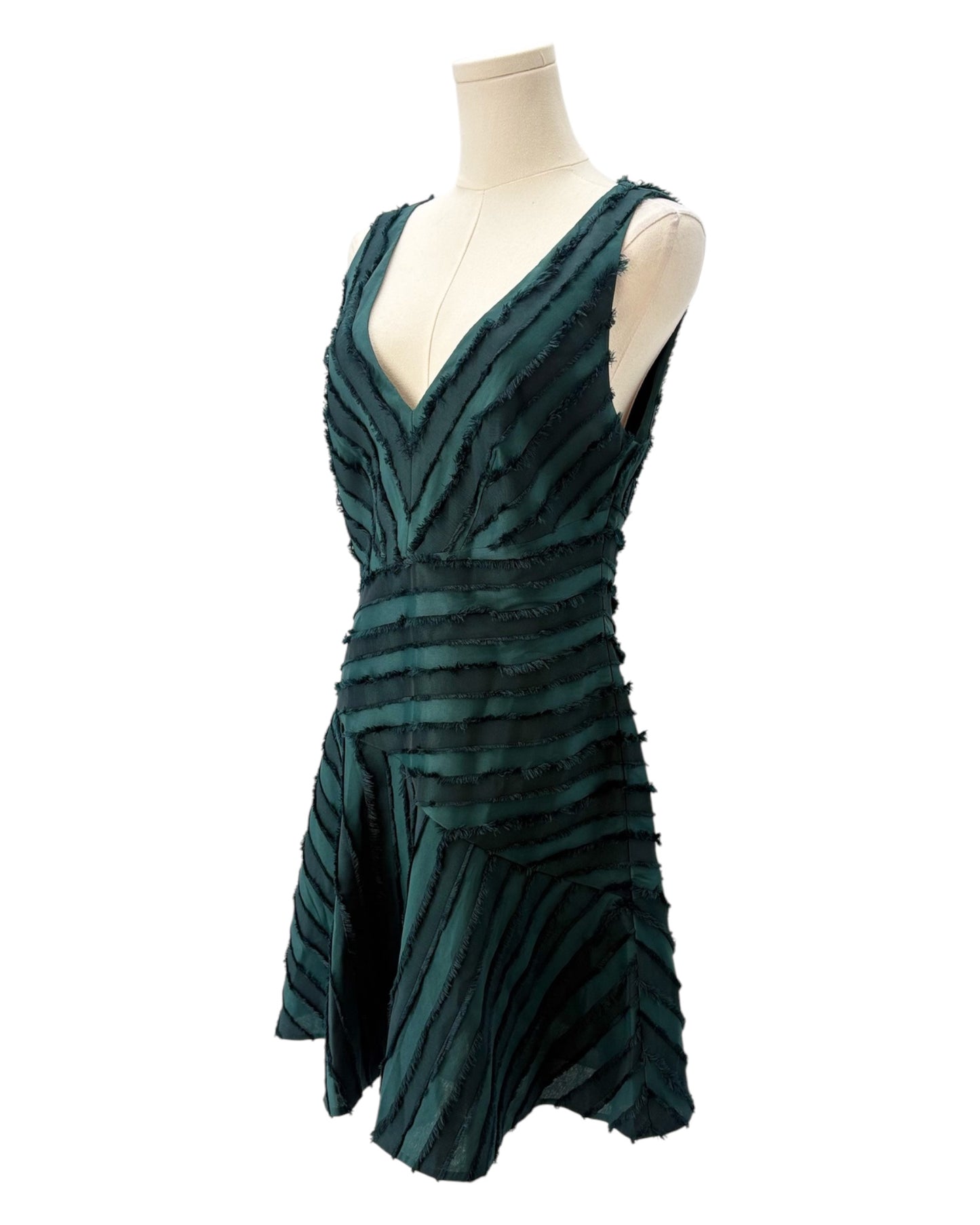Green dress on a mannequin against a white background