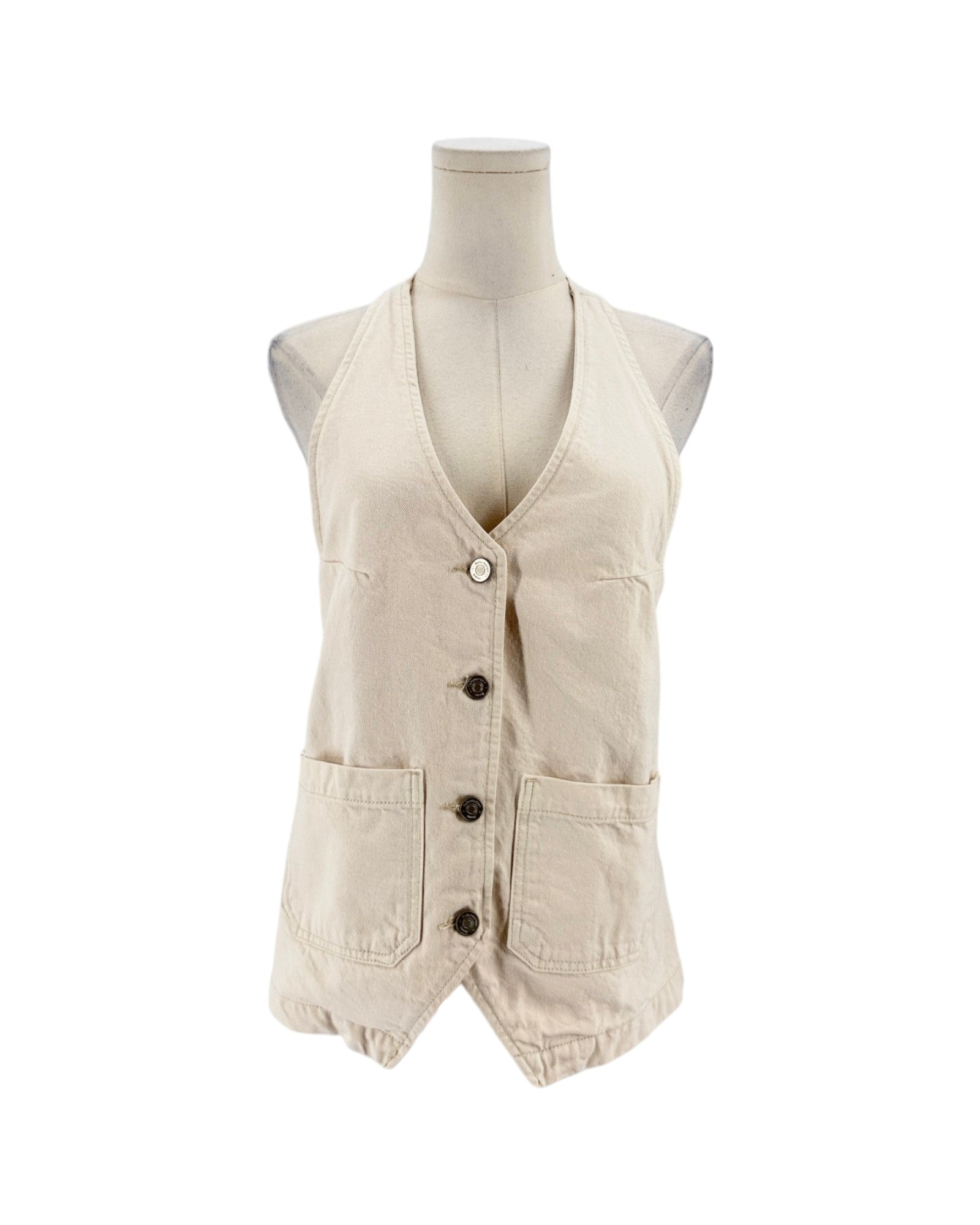 A sleeveless beige vest displayed on a mannequin torso against a plain white background. The vest has a V-neck, front button closure, and two large front patch pockets.