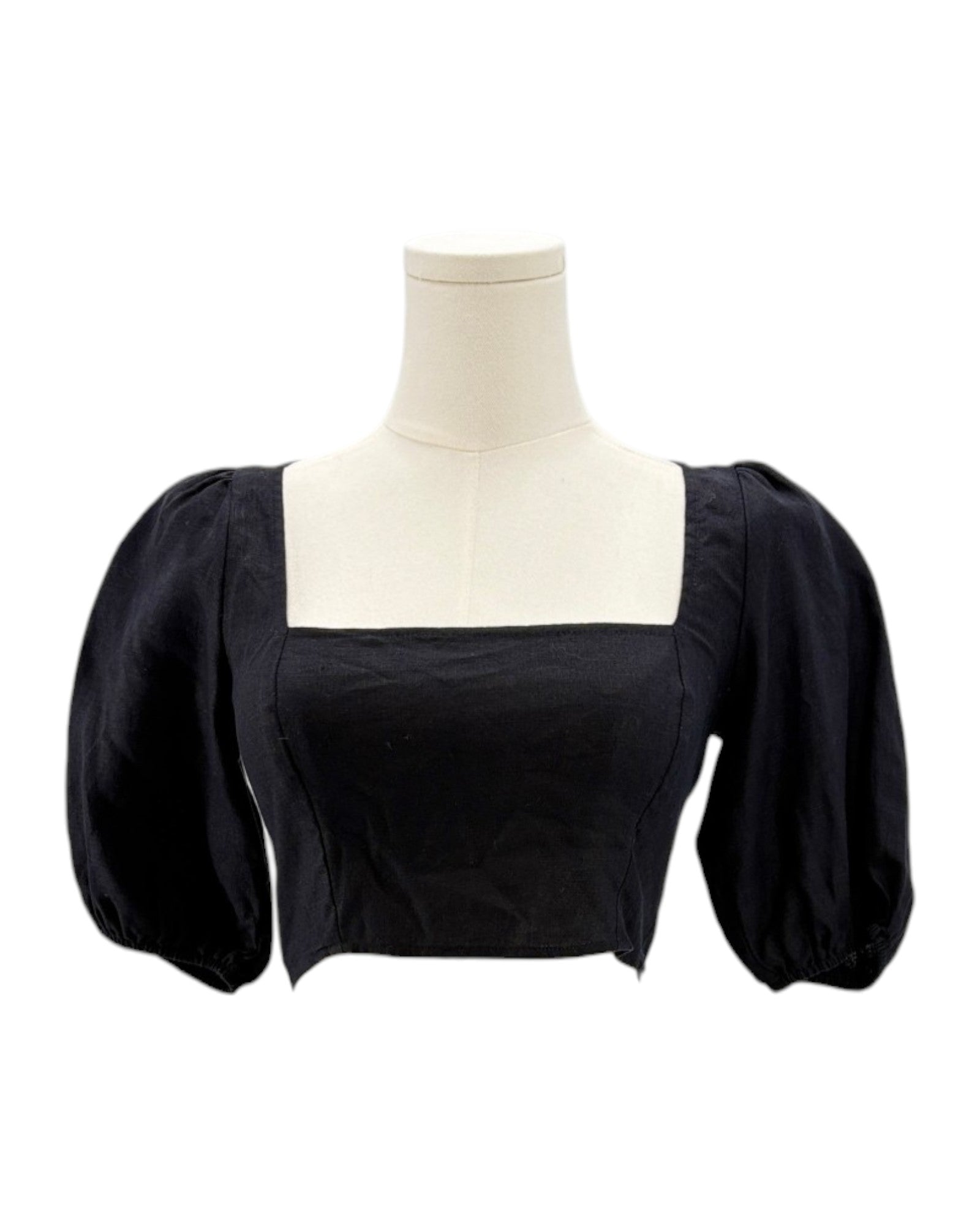 Reformation black blouse with puffed sleeves on a mannequin against a white background