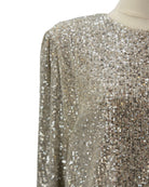Close-up of a gold sequin dress on a mannequin against a white background