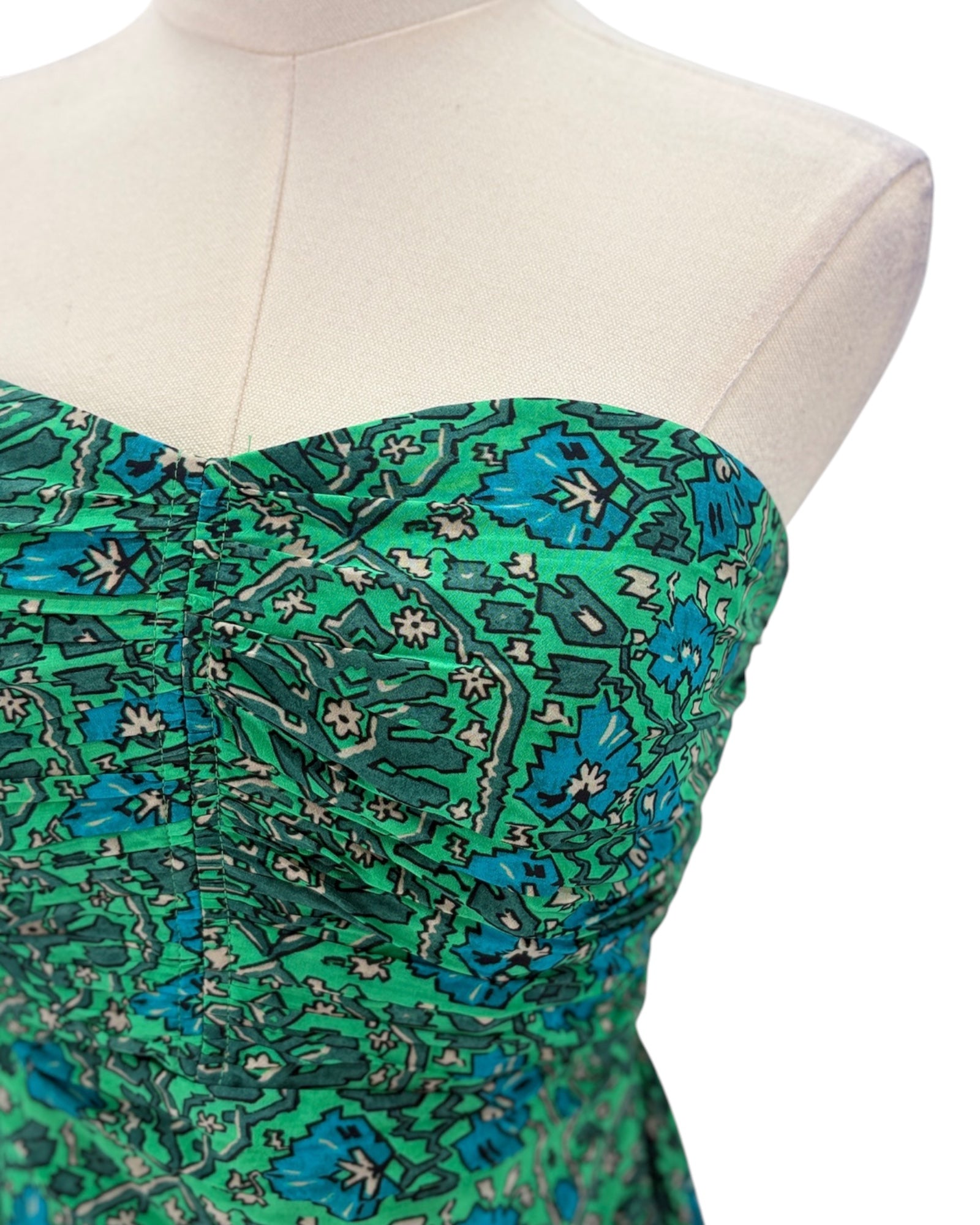 Green floral strapless dress on a mannequin with a white background