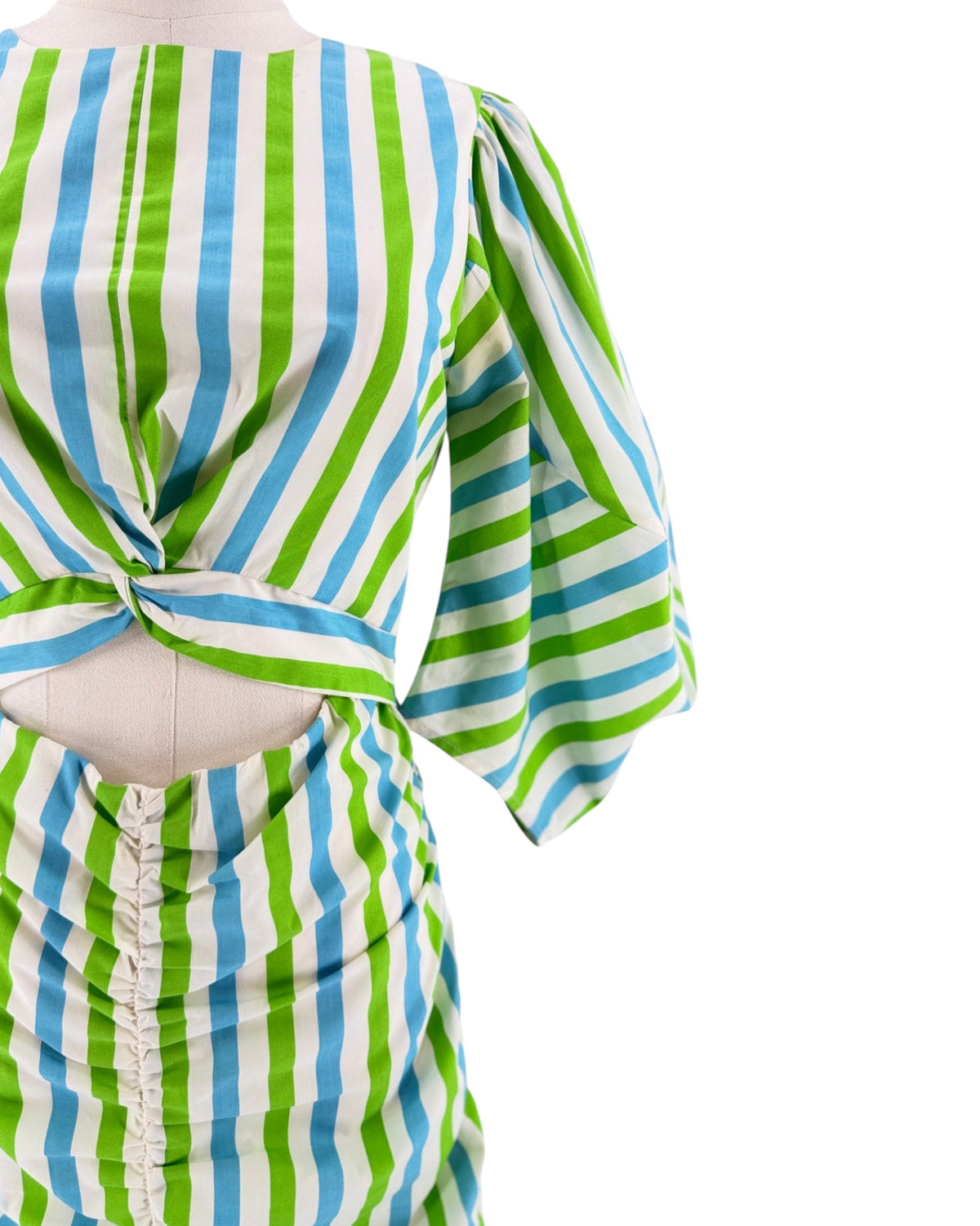 A close-up of a three-quarter sleeve top with a back knot detail, featuring vertical stripes in green, light blue, and white, displayed on a mannequin against a white background.