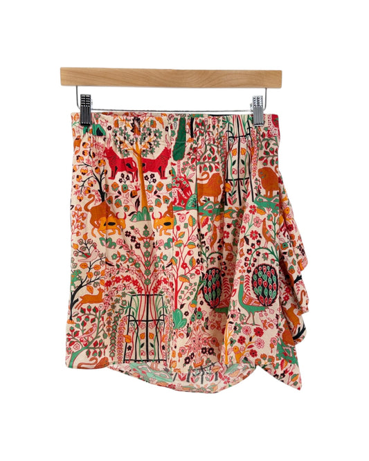 Patterned women's mini skirt with ruffle, featuring a vibrant, multicolored animal and floral print on a cream background, set against a plain white studio backdrop. white background