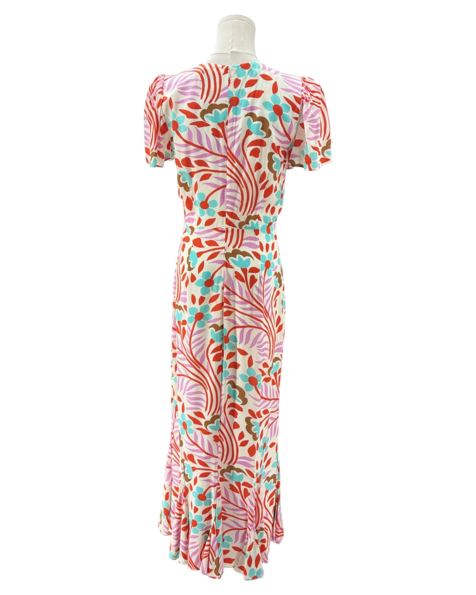 Colorful patterned dress on a mannequin against a white background