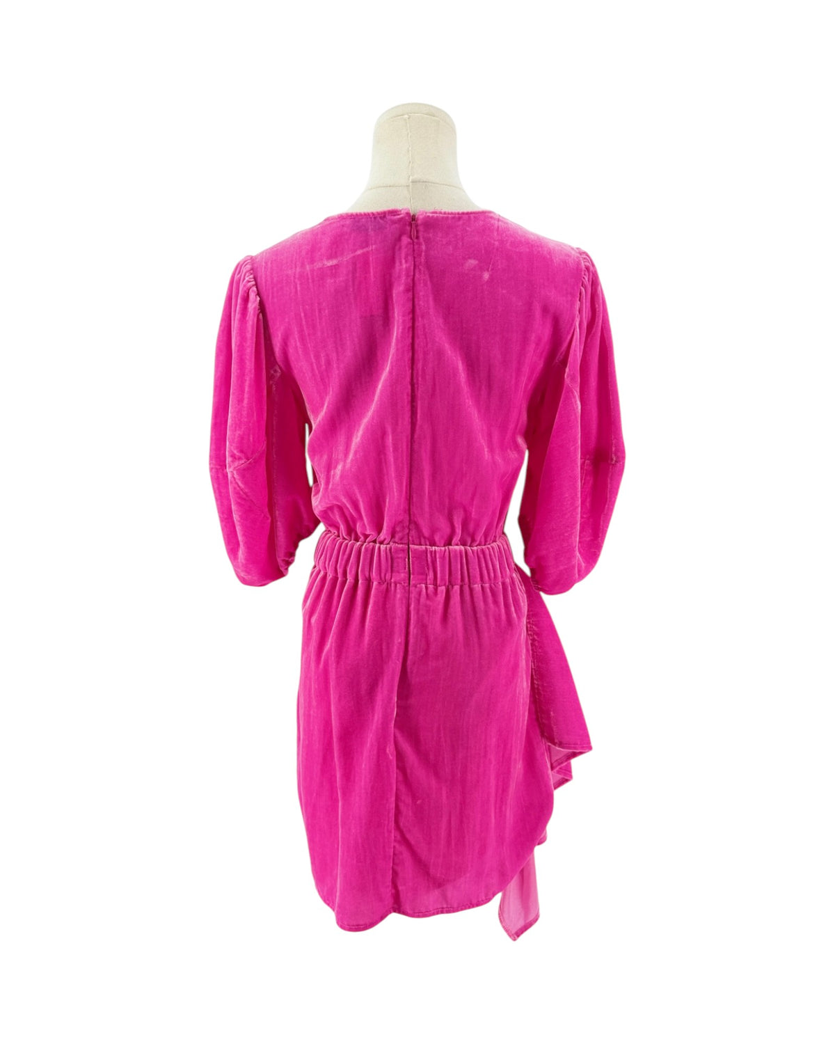 The back of a bright magenta pink velvet dress on a mannequin, showing the back of the neck, three-quarter puffed sleeves, and a matching fabric belt at the waist against a plain white background.