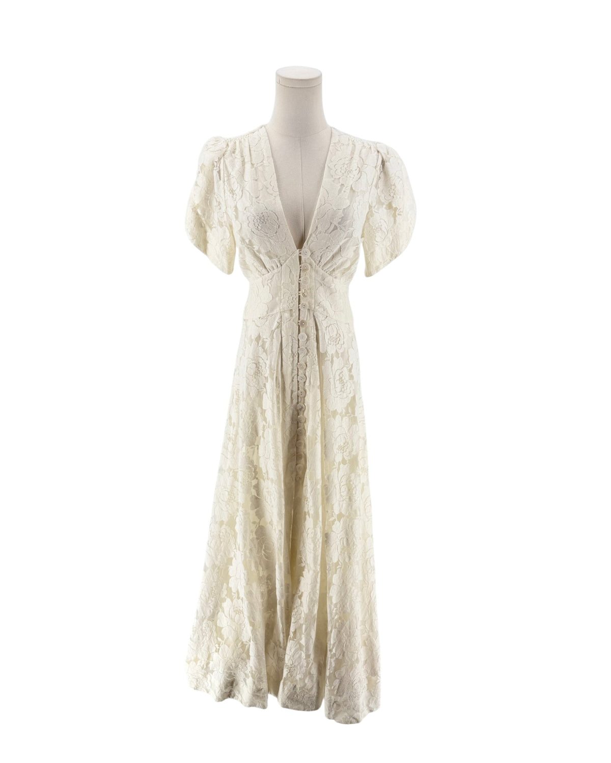 An off-white lace maxi dress with short puff sleeves, a deep V-neckline, and a lace-up front bodice, displayed on a mannequin against a white background.