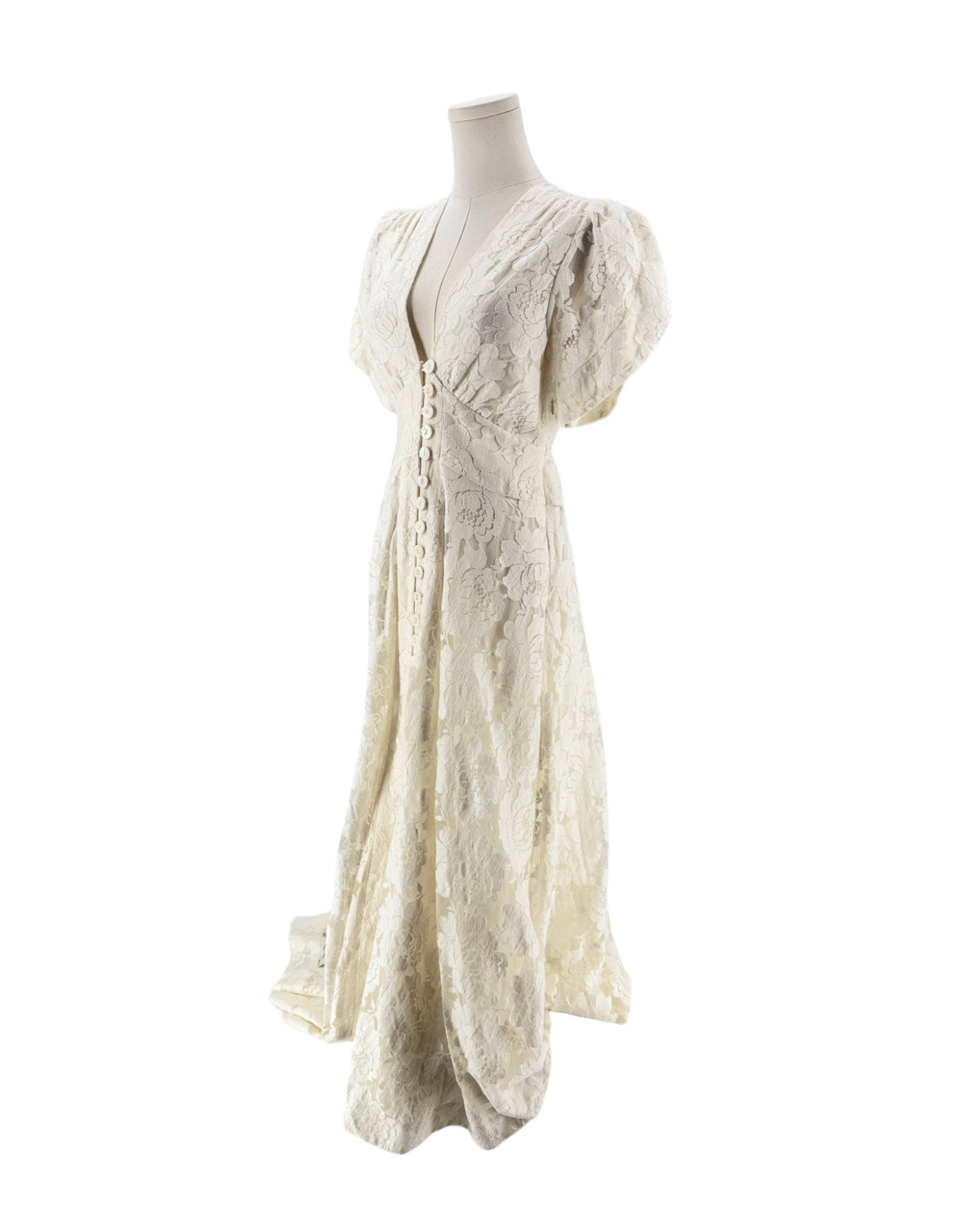 An off-white lace maxi dress with short puff sleeves, a deep V-neckline, and a lace-up front bodice, displayed on a mannequin against a white background.