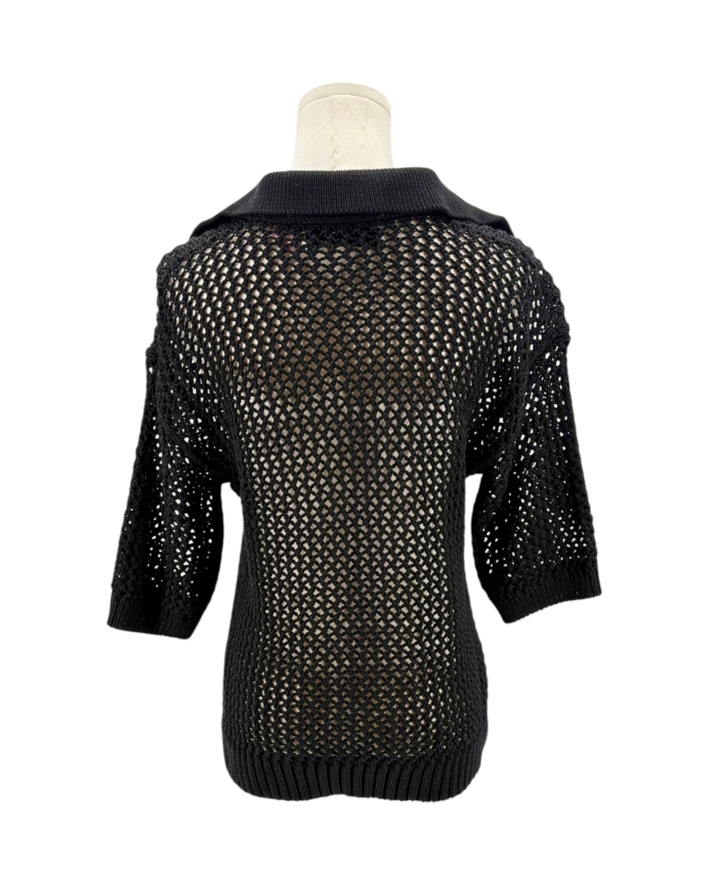 Black knit sweater on a mannequin against a white background