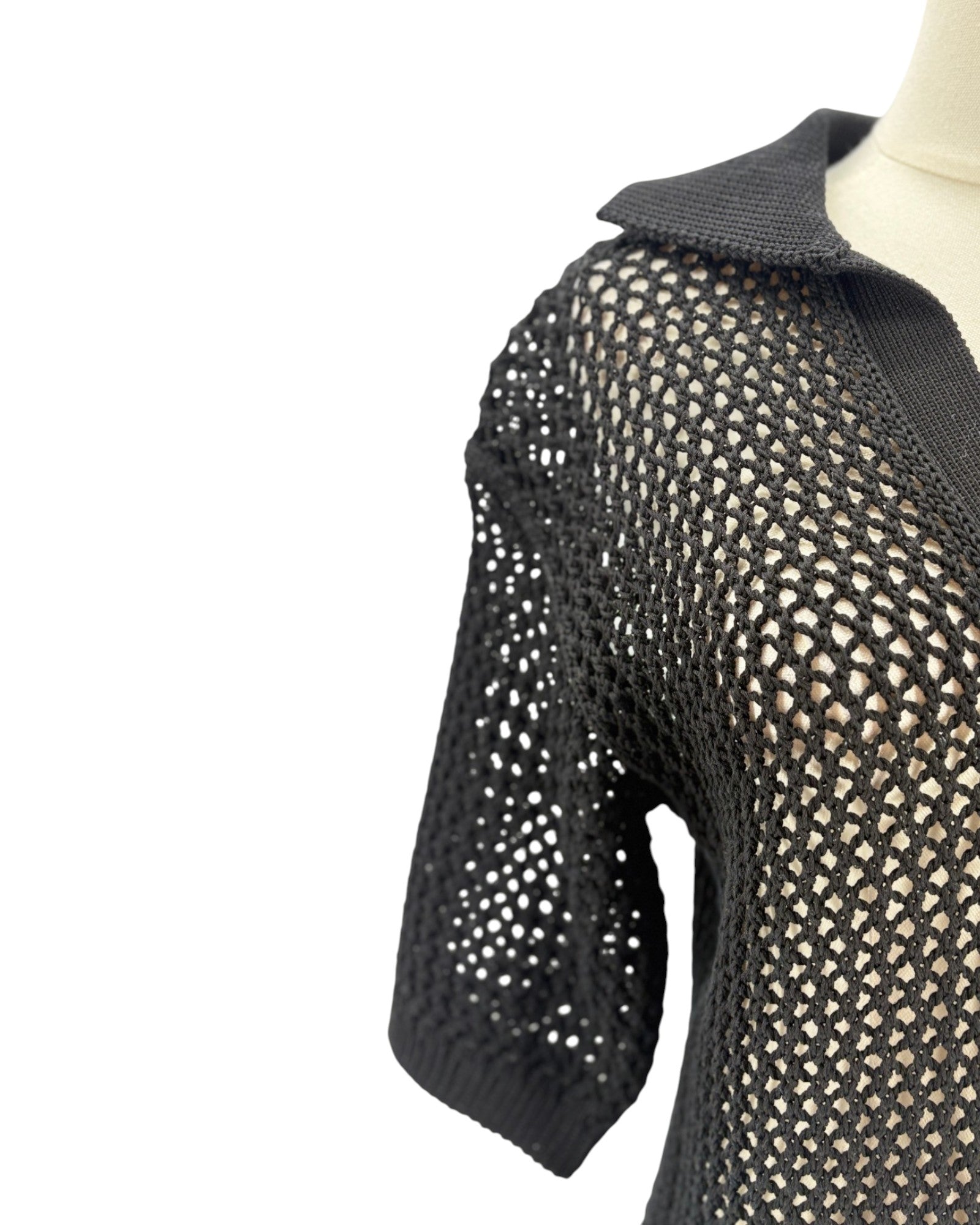 Black knit sweater on a mannequin against a white background