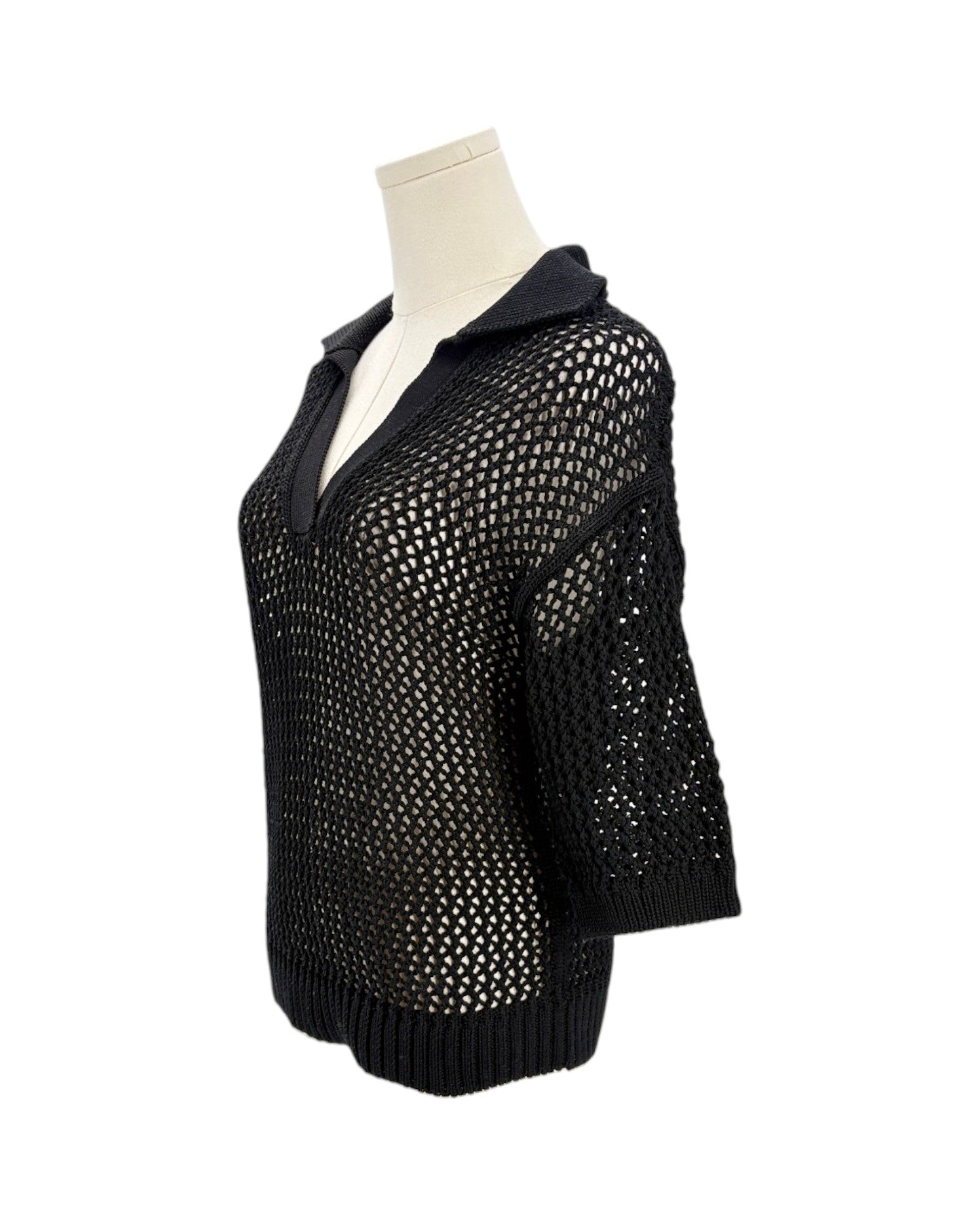 Black knit sweater on a mannequin against a white background