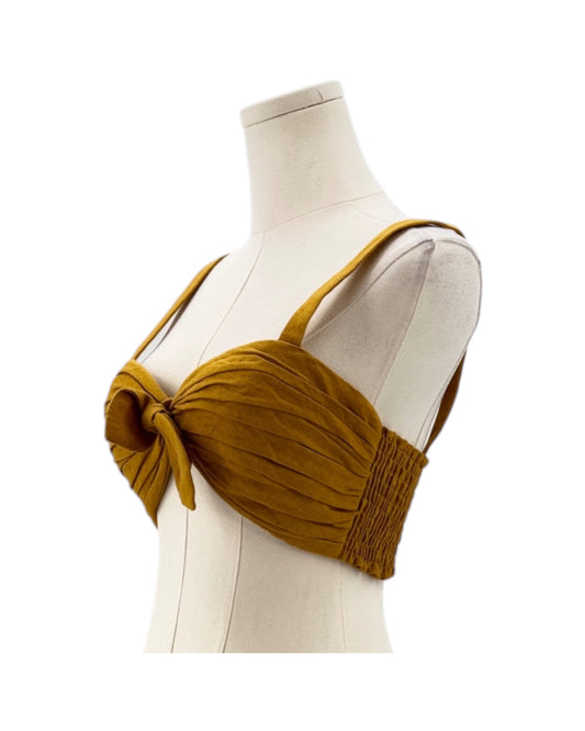 Mustard yellow top on a mannequin against a white background