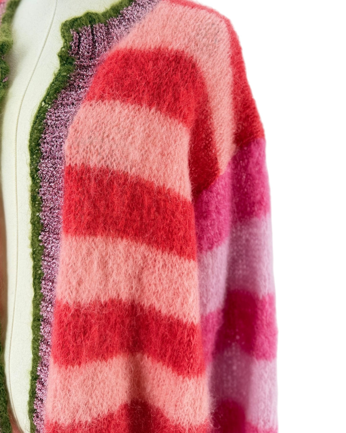 A fuzzy knit sweater with horizontal wavy stripes in shades of red, pink, and coral, displayed on a mannequin from the back against a plain white background.