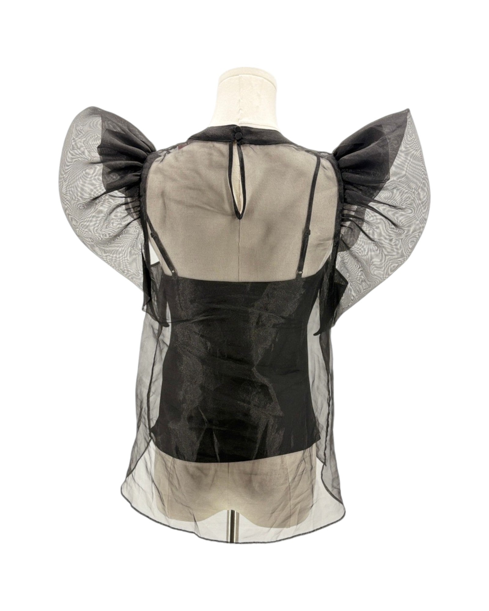 Mannequin wearing a black and beige outfit with sheer sleeves on a white background