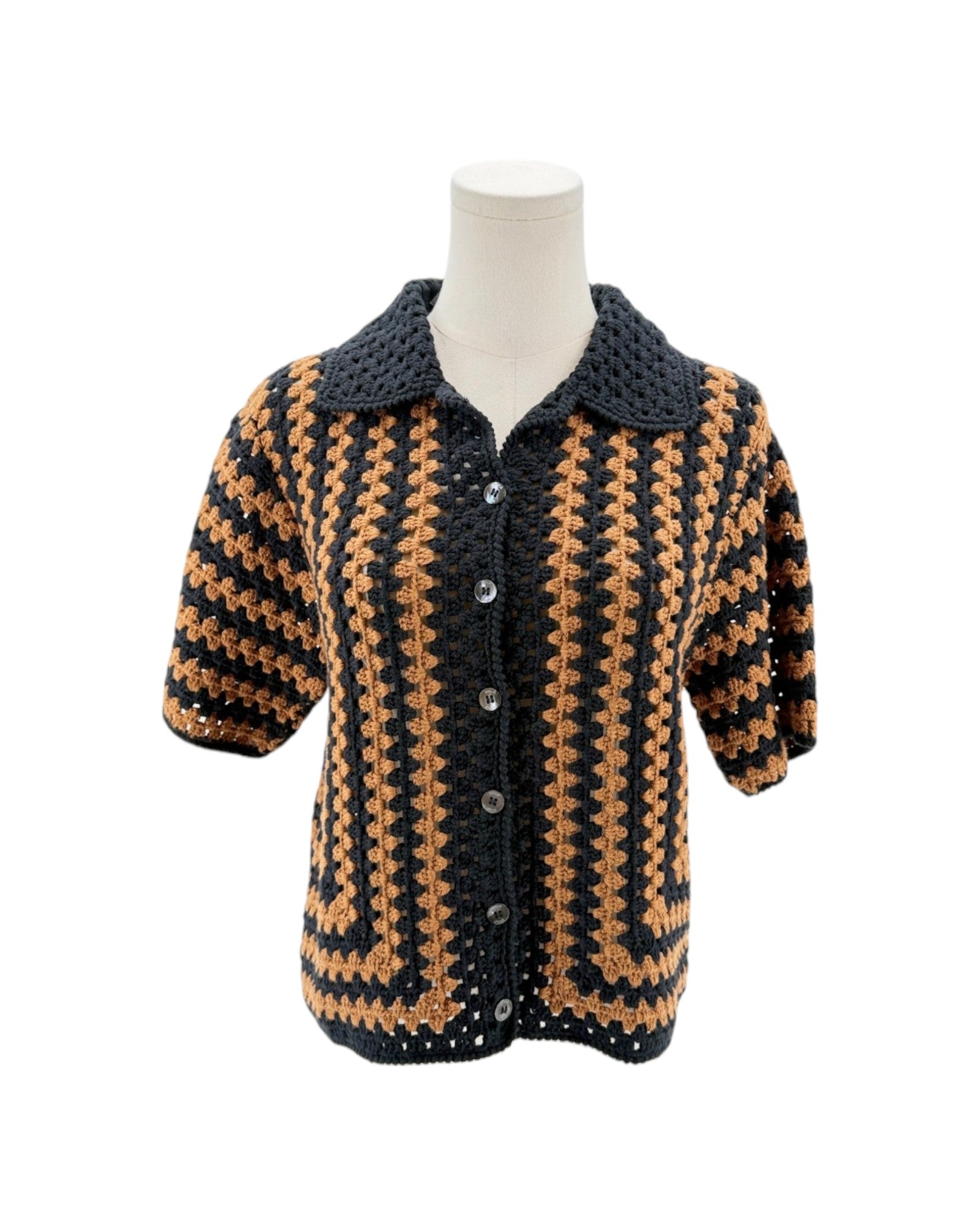 Crocheted black and brown patterned jacket on a mannequin against a white background