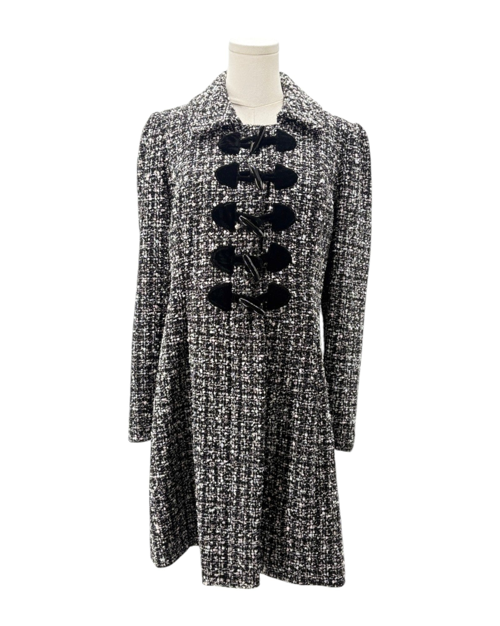 Tweed coat with black buttons on a mannequin against a white background