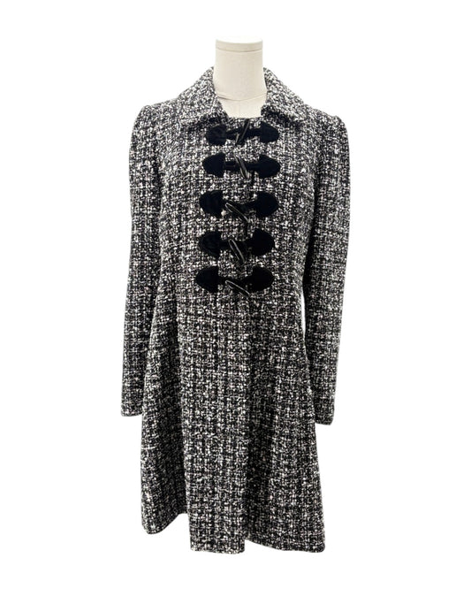 Tweed coat with black buttons on a mannequin against a white background