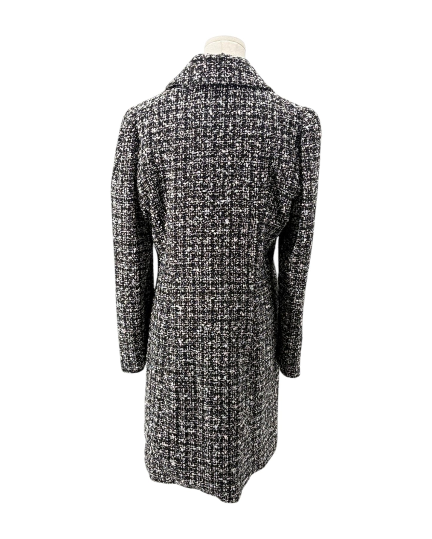 Black and white checkered coat on a mannequin against a white background