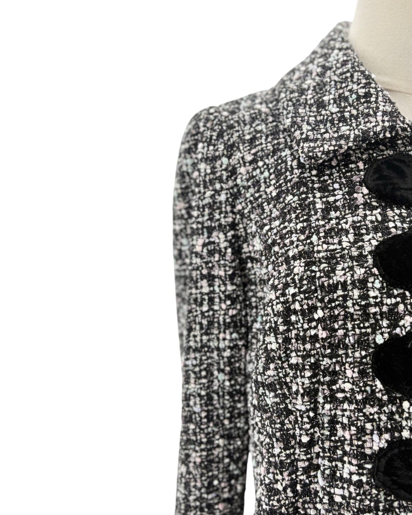 Black and white patterned coat with black buttons on a mannequin against a white background