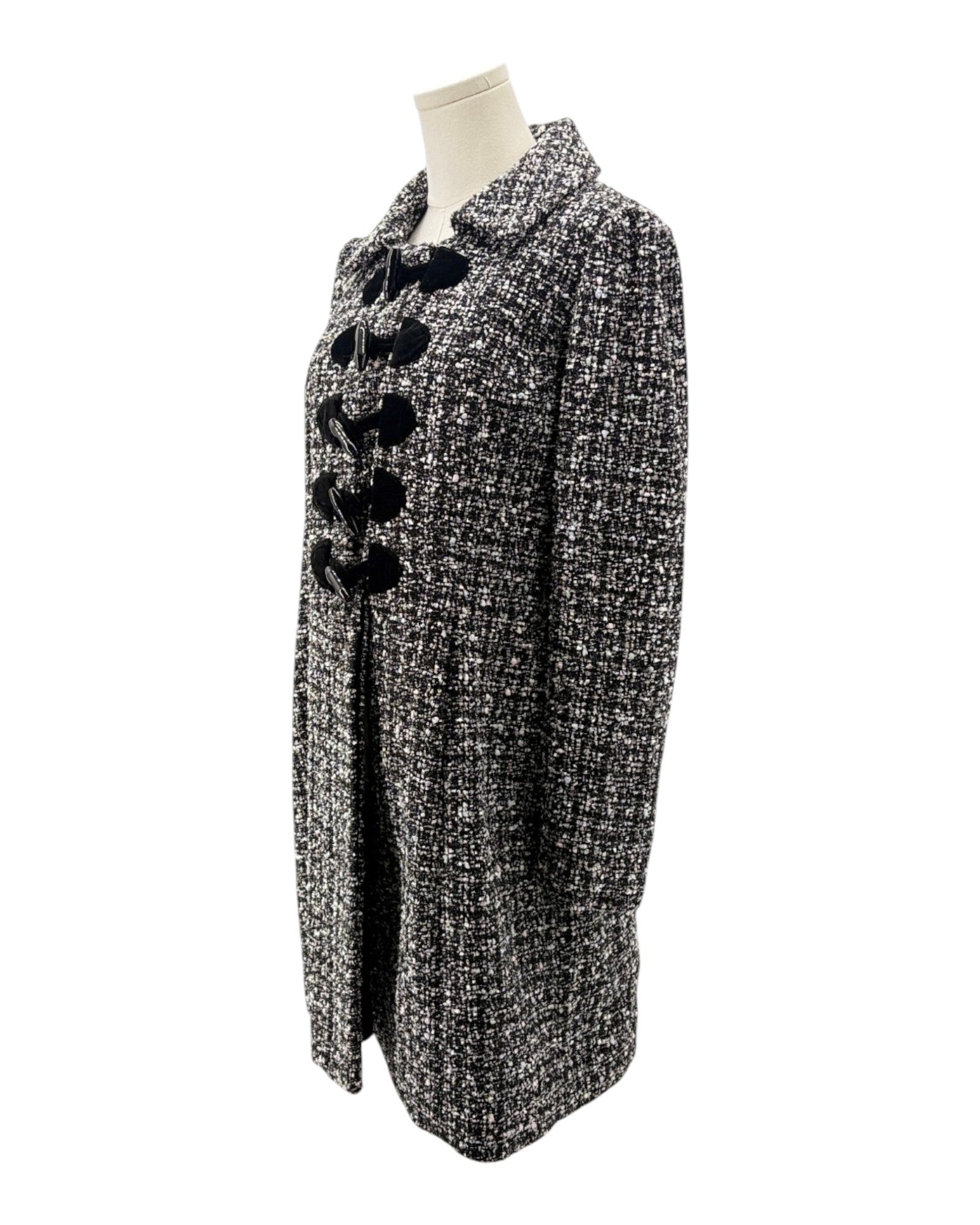Black and white patterned coat on a mannequin against a white background