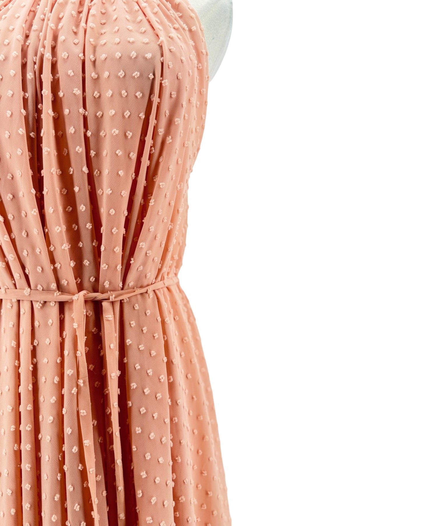 Peach-colored dress with a subtle pattern on a white background