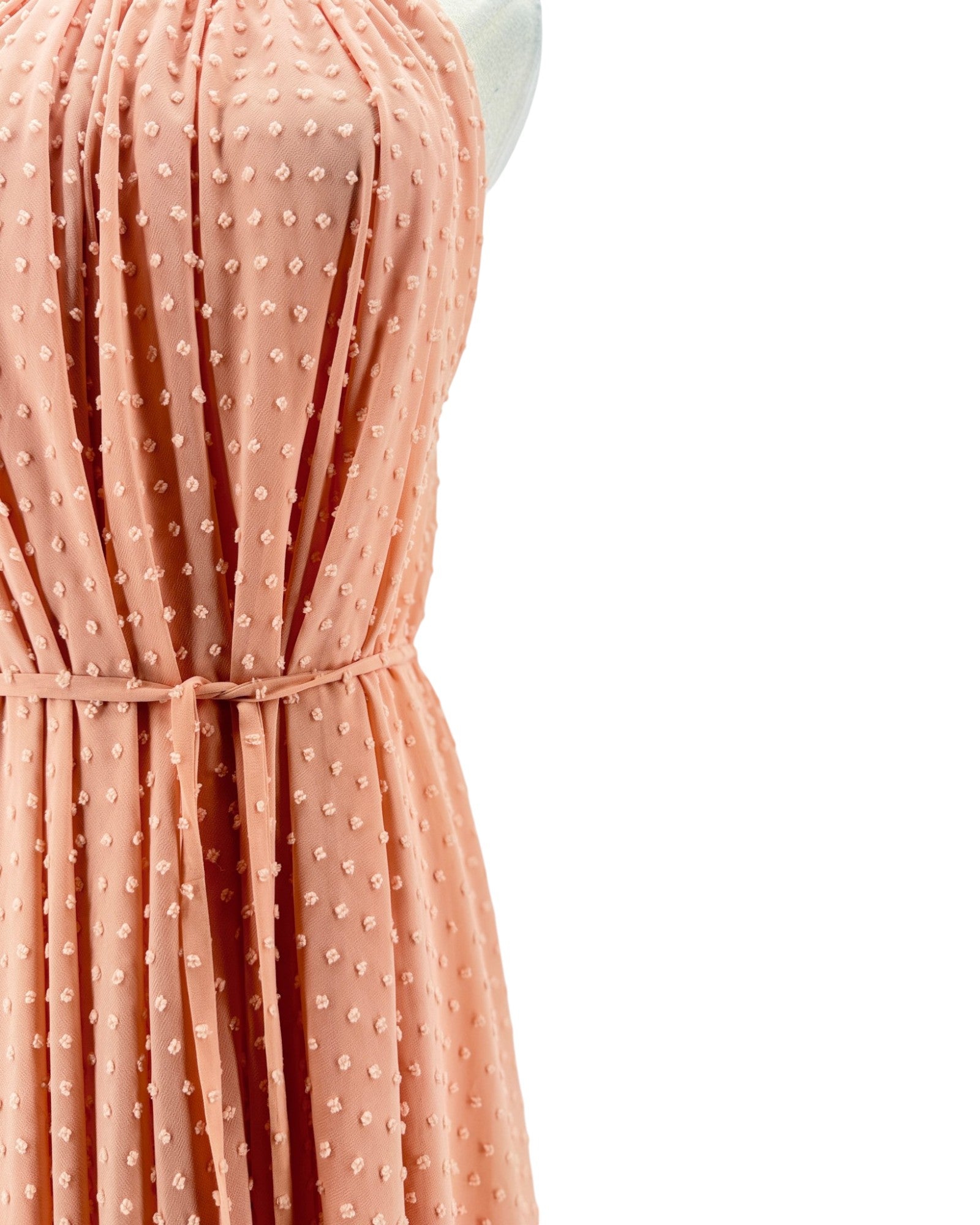 Peach-colored dress with a subtle pattern on a white background