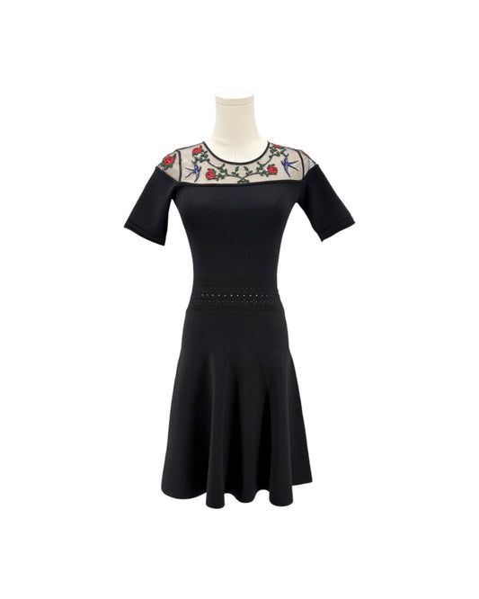 Black dress with floral embroidery on a white background