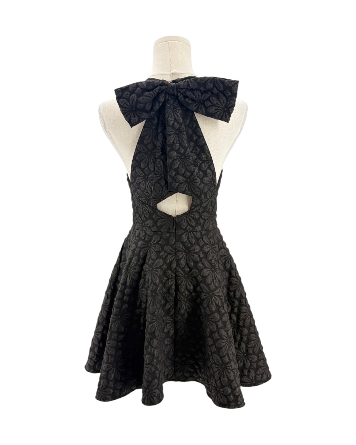Black dress with a bow on a mannequin against a white background