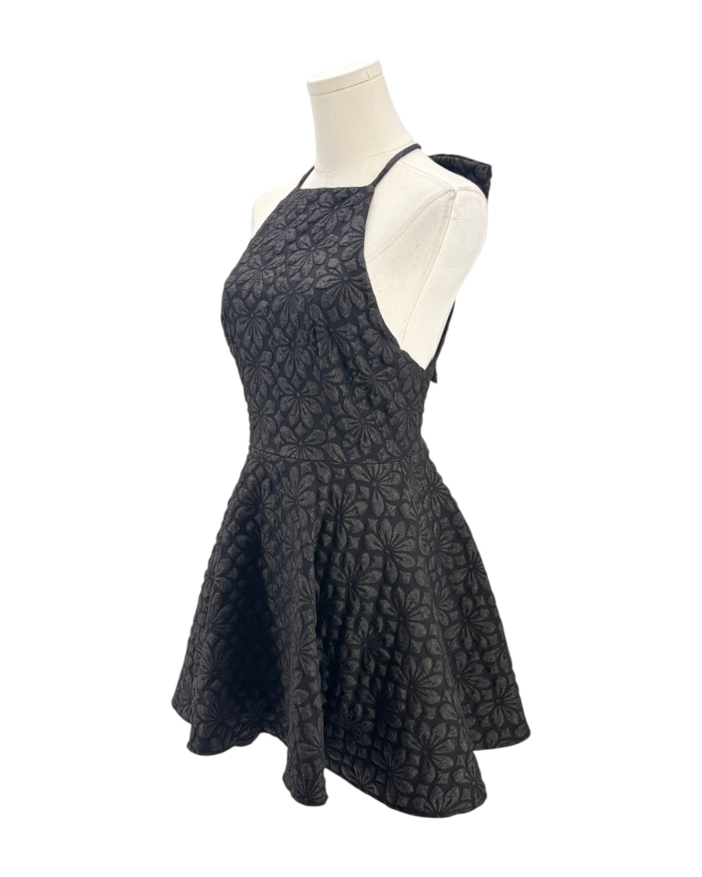 Black patterned dress on a mannequin against a white background