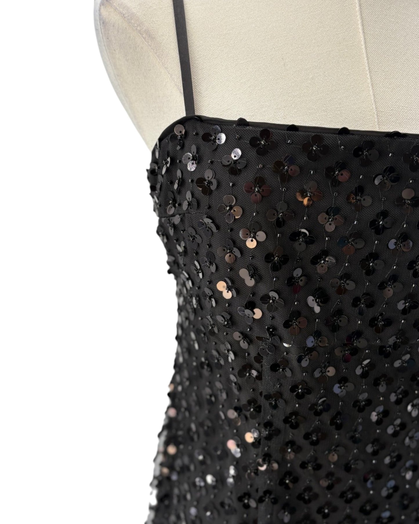 Black sequin dress on a mannequin with a white background