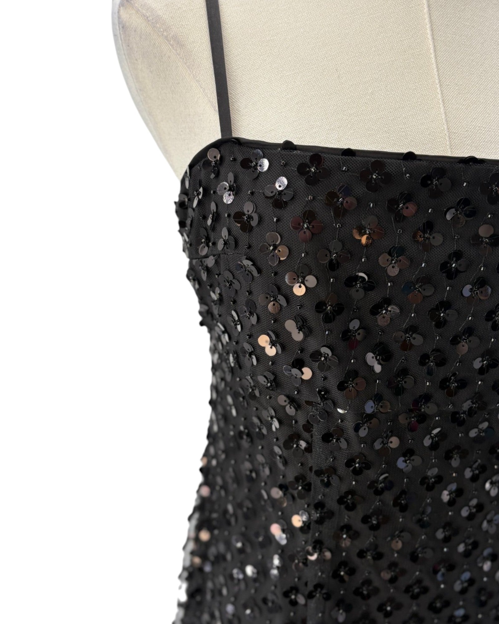 Black sequin dress on a mannequin with a white background