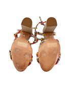 Pair of high-heeled shoes with colorful beaded straps on a white background