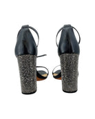 Black high-heeled shoes with rhinestone embellishments on a white background