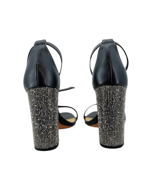 Black high-heeled shoes with rhinestone embellishments on a white background