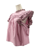 Pink blouse with ruffled details on a mannequin against a white background