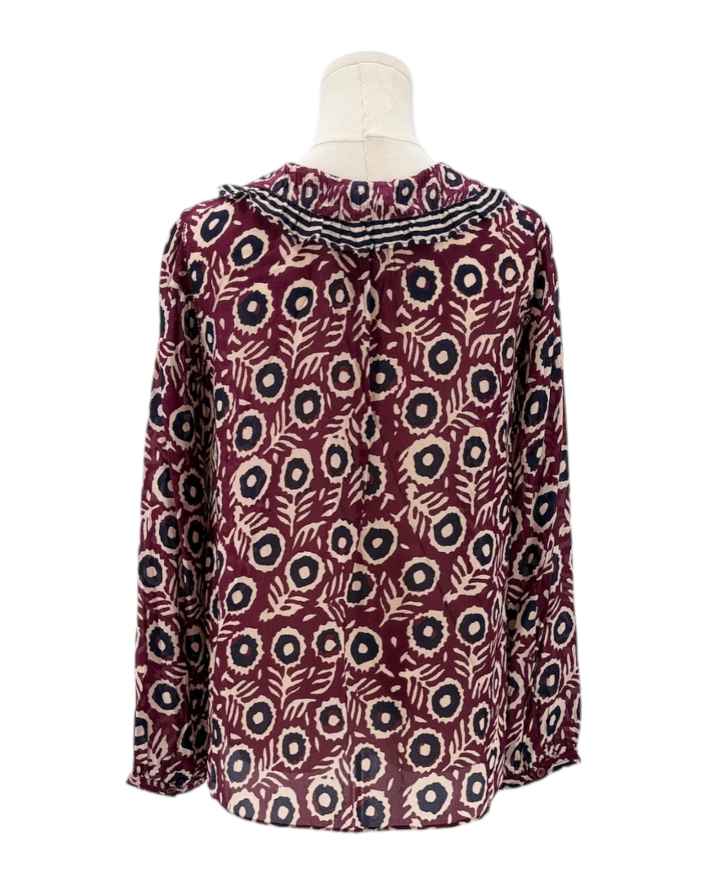 Patterned blouse on a mannequin against a white background
