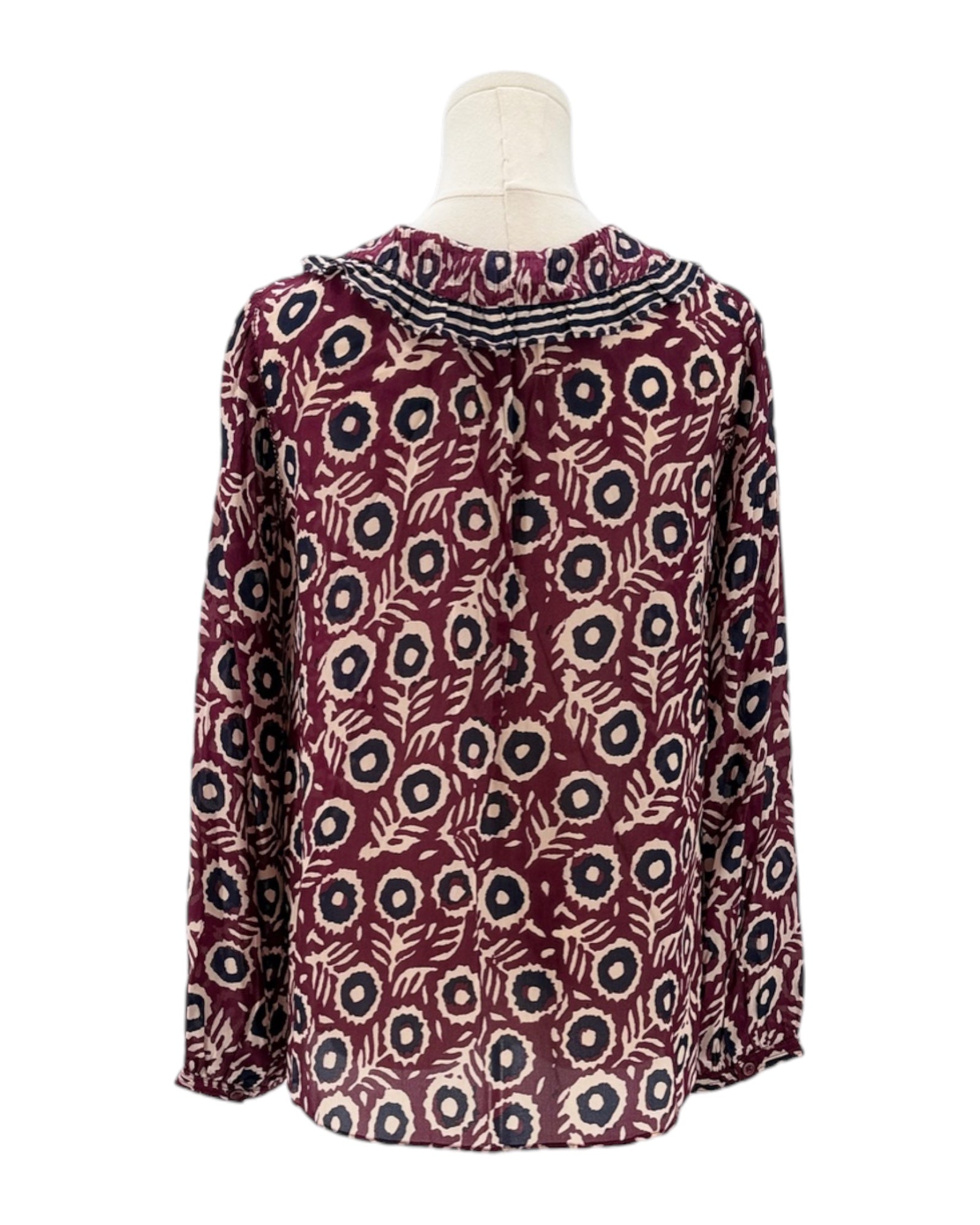 Patterned blouse on a mannequin against a white background
